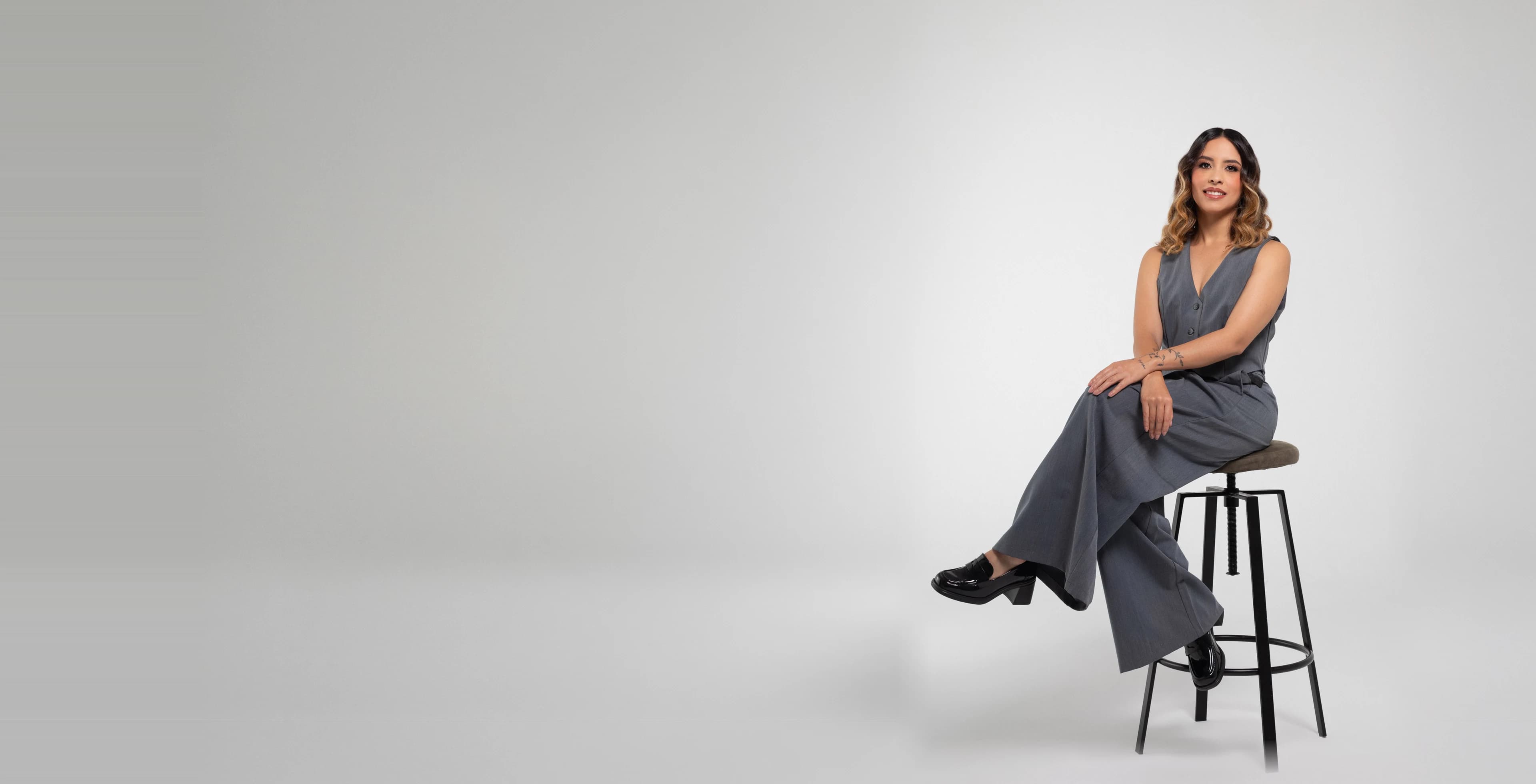 Katherine Velasquez, 360 strategist and civil engineer, seated on a studio bench