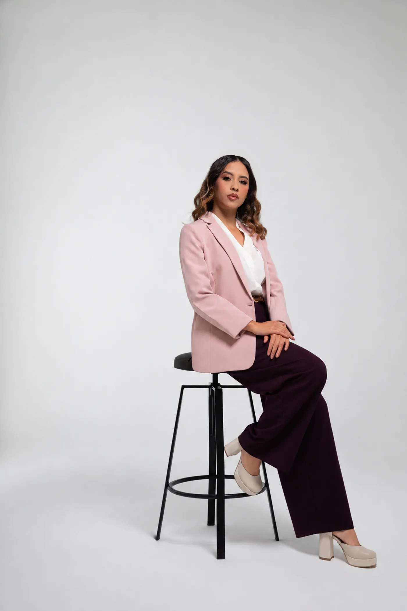 Katherine Velasquez in a pink blazer, seated in a studio
