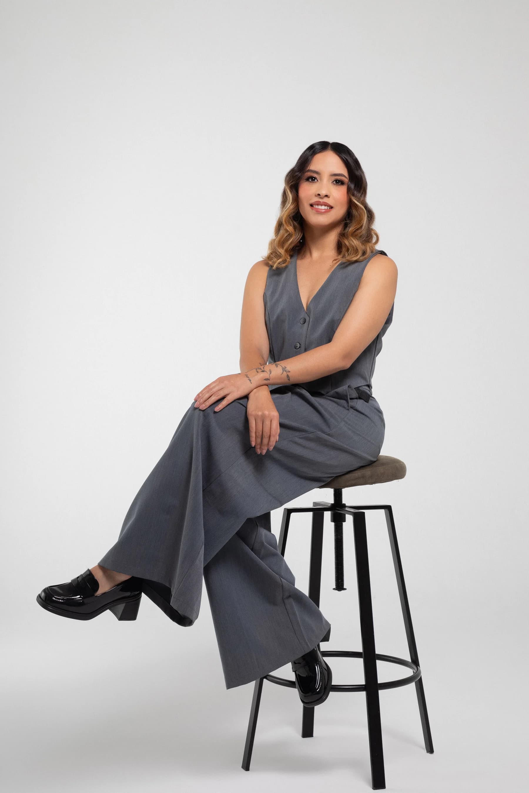 Katherine Velasquez, 360 strategist and civil engineer, seated on a studio bench