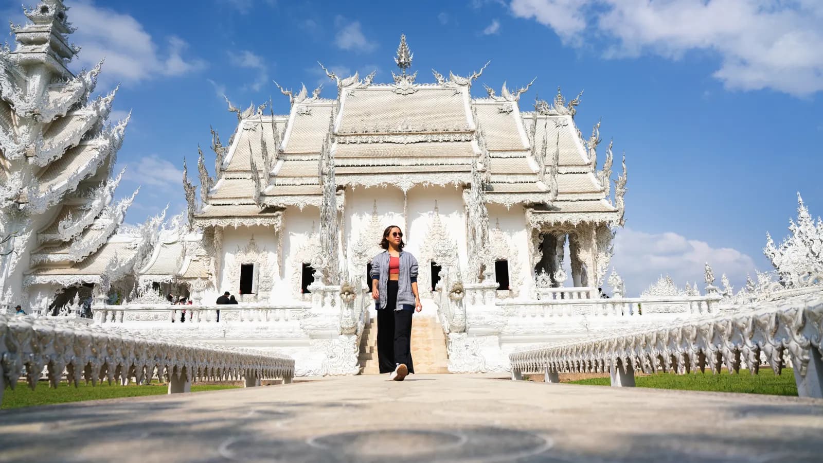 Katherine Velasquez caminando frente al Templo Blanco de Chiang Rai, Tailandia