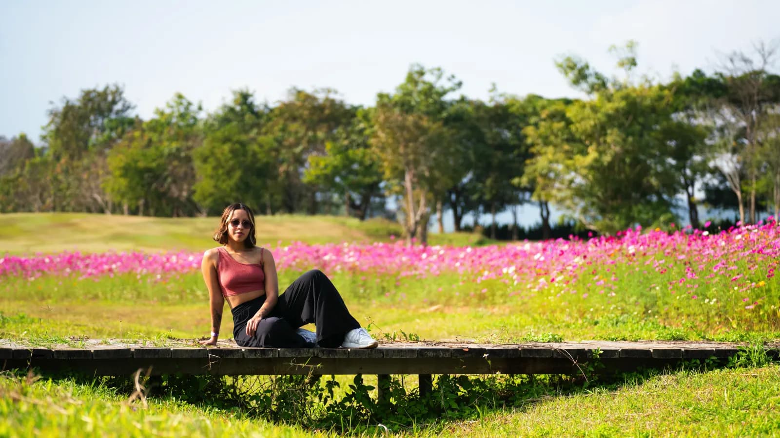 Katherine Velasquez descansando en un campo de flores rosadas